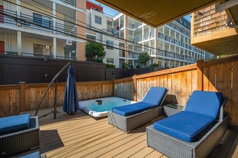 Private patio w/ cushioned loungers & cozy seating, perfect for relaxing outdoors after a day in the city