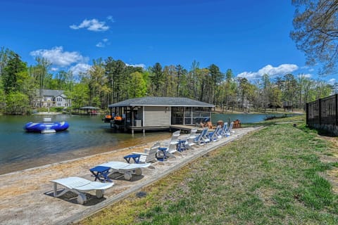 Lakefront - Private sandy beach with lounge chairs lined along the water, dock and trampoline just a few steps away.
