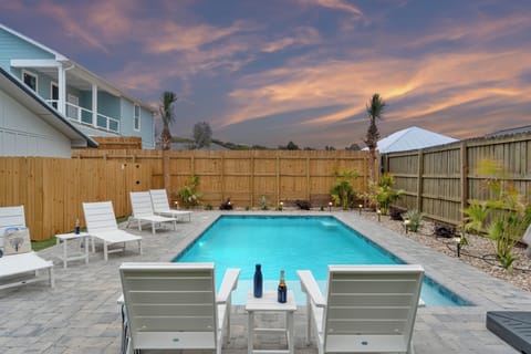 Sunset‑side pool patio with relaxed loungers, cool drinks, and a peaceful backyard view.