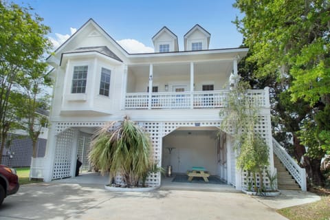 Birdies and Beaches: Charming coastal retreat with tropical landscaping and convenient parking, nestled among lush palm trees and mature vegetation.