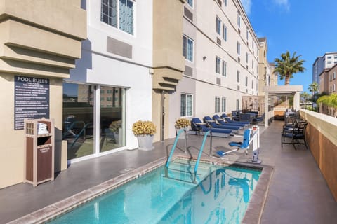 Dive into a sunny pool retreat with loungers nearby.