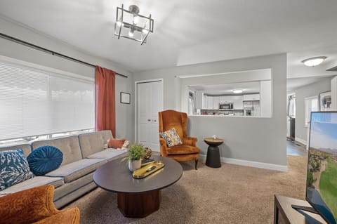 Open living space w/ plush carpet, accent chair & easy flow between rooms.
