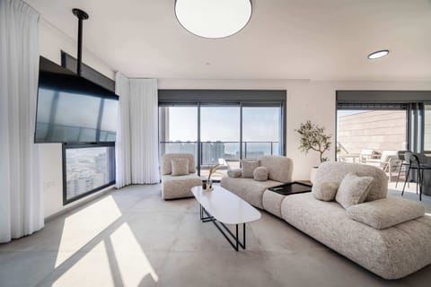 Open-plan relaxation hub featuring curved furnishings, statement lighting, seamless balcony flow, perfect entertaining ambience.