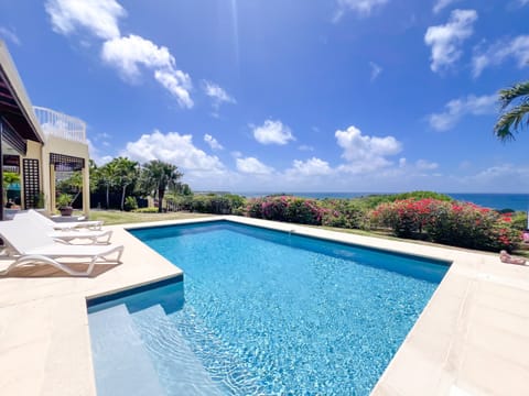 View of the private swimming pool and panoramic sea view from the terrace of Villa Lagonys in Le Gosier, Guadeloupe.