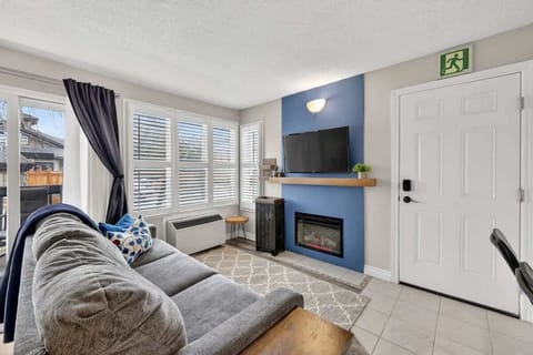Cozy up by the electric fireplace in the bright, inviting living room