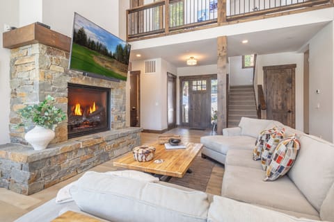 Sink into plush sofas by the crackling stone fireplace, while natural light streams through soaring windows in this beautifully appointed mountain retreat.