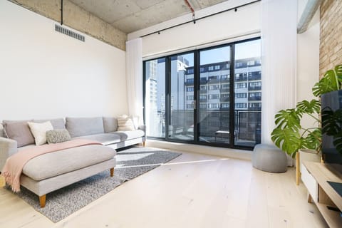 Sunlit living area opening to a private balcony, bringing the outdoors in.
