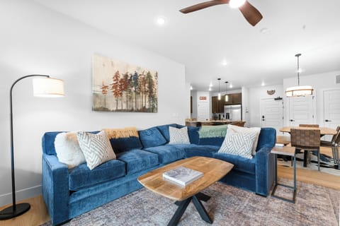 Sink into plush blue velvet seating in your inviting open-concept space, where modern mountain charm meets effortless relaxation and every detail invites you to unwind.