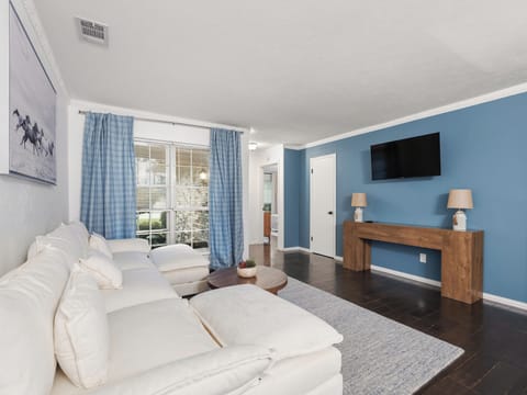Sink into your plush white sectional while enjoying your favorite shows on the wall-mounted TV in this bright living space.