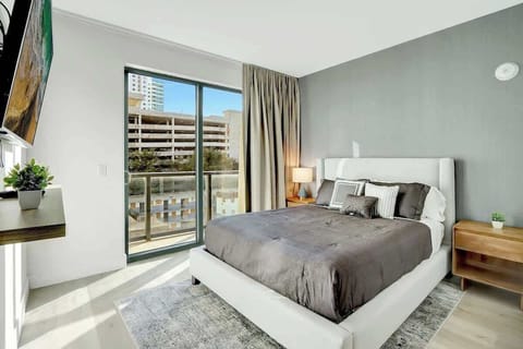 Cozy bedroom with smart TV and a direct balcony access.
