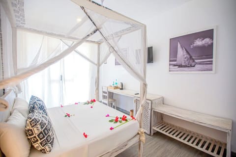 Sink into crisp linens beneath flowing nets and soft light.