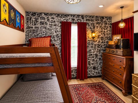 Step into magic! This Harry Potter-themed kids' bedroom features cozy wood-frame bunk beds, enchanting decor, and a fun atmosphere perfect for young wizards.
