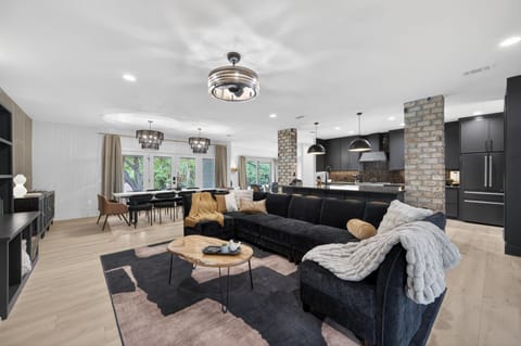 The heart of the home—an open-concept gathering space where the oversized sectional, chef's kitchen, and 12-foot dining table bring everyone together.