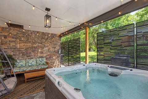 Sink into your private hot tub while twinkling lights create a magical atmosphere on this covered patio.