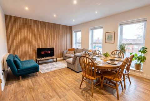 Bright open-plan living and dining space with a striking timber feature wall and city views.