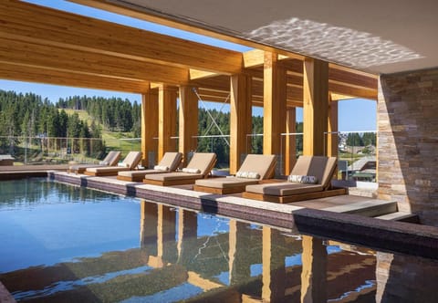 Lounge in the sun beside a sparkling mountain-view pool.