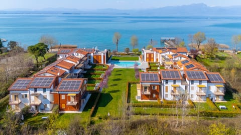 A modern residence on Lake Garda featuring apartments, a central pool, and spacious green areas. The property is located right on the lake, offering a peaceful and scenic setting that’s ideal for relaxing vacations surrounded by nature and comfort.