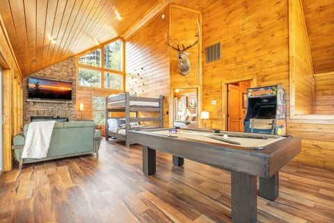 Challenge friends to pool while relaxing by your warm fireplace in this rustic loft with cozy bunk beds.
