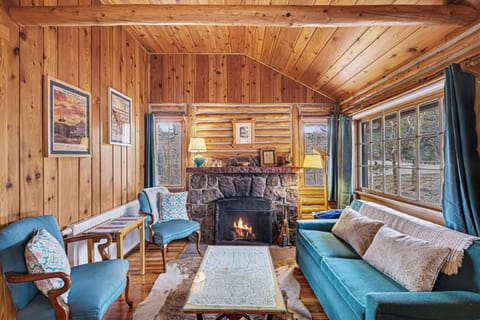 Enjoy the cozy living room with old timey log walls and crackling fireplace.