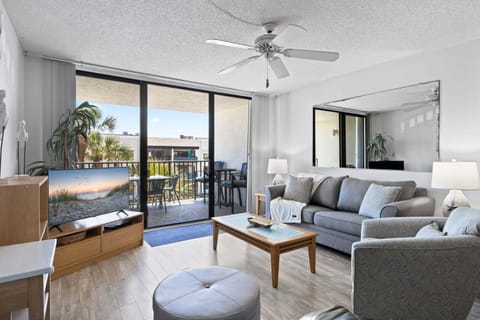Bright & airy living room with sliding glass doors lead to outdoor balcony