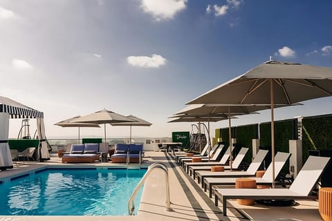 Unwind poolside under oversized umbrellas with resort-style loungers.