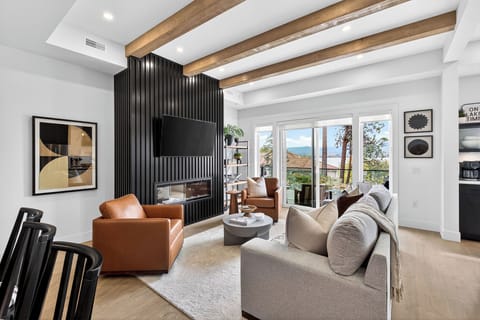 Bright open living space with cozy seating, fireplace, and beautiful outdoor views