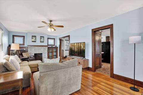 A comfortable living room featuring plush seating, a TV, and a fireplace, seamlessly connected to the dining area for an open and inviting feel.