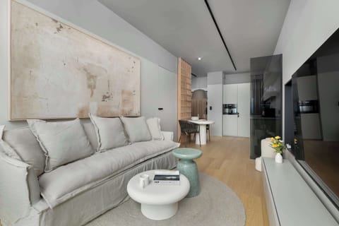 Another angle of the living space showing the sofa and decorative wall art. The layout feels open and well-balanced with modern furnishings.