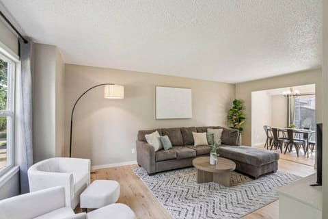 Living Room | Unit 2 | Main Floor
Shared living space with sectional sofa, accent chairs, and coffee table. Floor lamp for lighting. Open layout with direct access to the dining area and kitchen. Located near the front entry and stair access.