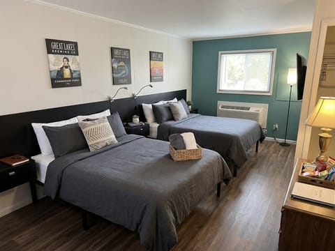 Brewery-themed bedroom with two comfortable beds, craft beer artwork, and a warm teal accent wall