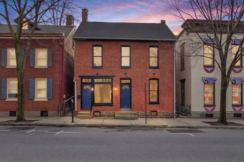 This is what 160 years of Gettysburg history looks like from the sidewalk — a classic brick façade, bold blue doors, and a sunset that feels like it was staged just for you.