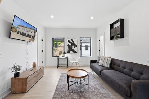 Open-concept living space featuring comfortable modern seating, a flat-screen TV, and plenty of natural light.