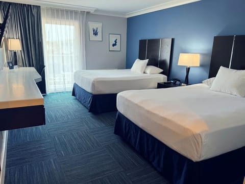 Unwind in a spacious double-queen room with calming blue tones.