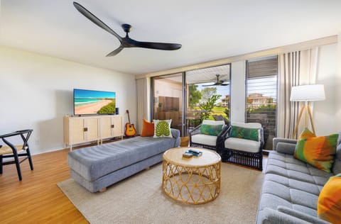 Light-filled living room with seating and tropical lanai views