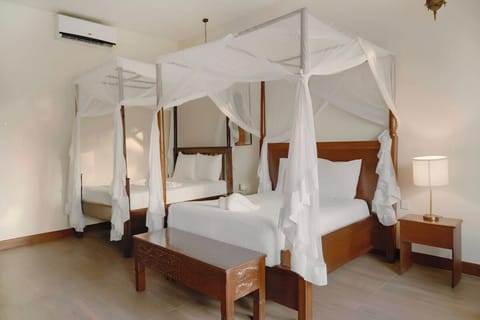 Settle into crisp linens under a soft, romantic canopy drape.