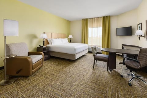 Relax into plush bedding with a lounge chair and soft light.