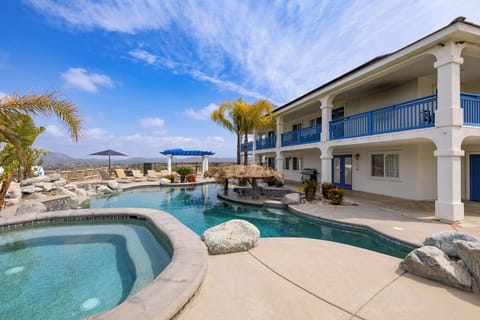Resort‑style pool and spa with tropical landscaping and hillside views for laid‑back lounging.