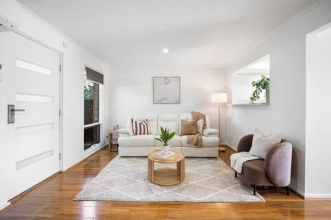 Unwind in this light-filled living area, where a calming neutral palette and thoughtfully styled furnishings create an inviting space to relax.