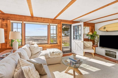 Cozy, bright living room with lots of natural light, a Smart TV, and plenty of seating. Overlooking the Duck Meadow Tidal Marsh. The living room has a Natural Gas fireplace.