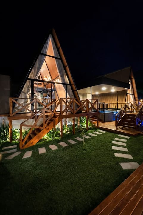 A Cabana Country da Vivendas Ferreira ganha um charme especial à noite. A iluminação quente valoriza cada detalhe da arquitetura em madeira, criando um cenário sofisticado e acolhedor.
