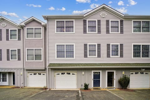 Two-story townhome building with multiple units, each featuring individual garage access and private entrances. The property offers convenient parking and a residential neighborhood setting.