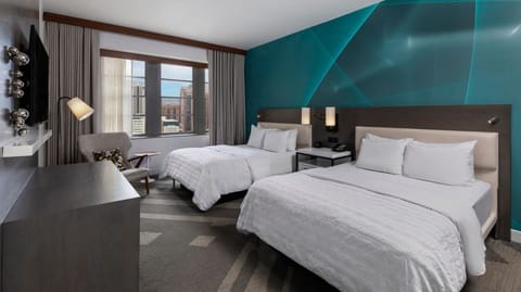 Unwind in crisp twin beds beneath a bold feature wall