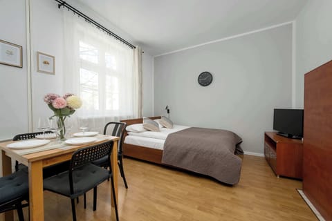A cozy studio space combining a bed and seating area in one room. It is designed for comfort and practical use in a compact layout.