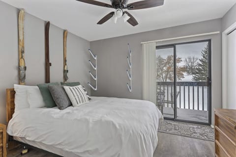 Cozy main-level queen bedroom with soft linens and private balcony access—wake up to fresh mountain air.