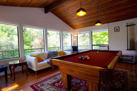 Pool table with cozy seating, large windows on three sides.