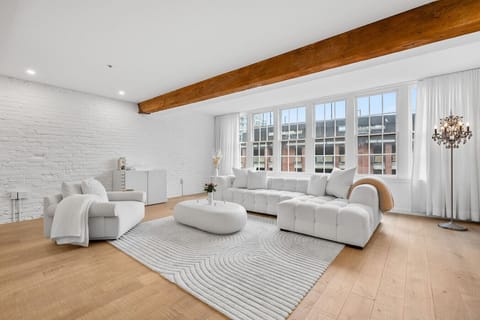 Bright and spacious living room with oversized windows, comfortable seating, and a modern design.