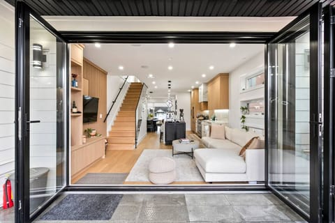 Open-concept living with floor-to-ceiling doors connecting to outdoor space.  Living Room: Sleek design meets outdoor bliss with expansive doors for seamless flow!