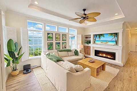 Relax in this bright, coastal-inspired living room with soaring ceilings, cozy seating, and a sleek fireplace. Sunlight pours through oversized windows, creating the perfect space to unwind after a day on the lake.