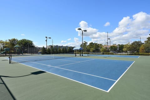 Bright blue tennis courts set against a sunny sky offer an inviting spot for an active afternoon.
