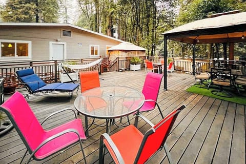 Your deck has room for everyone — hammock naps, lounge-chair reading, and covered dining all unfold under a breathtaking redwood canopy steps from the Russian River.